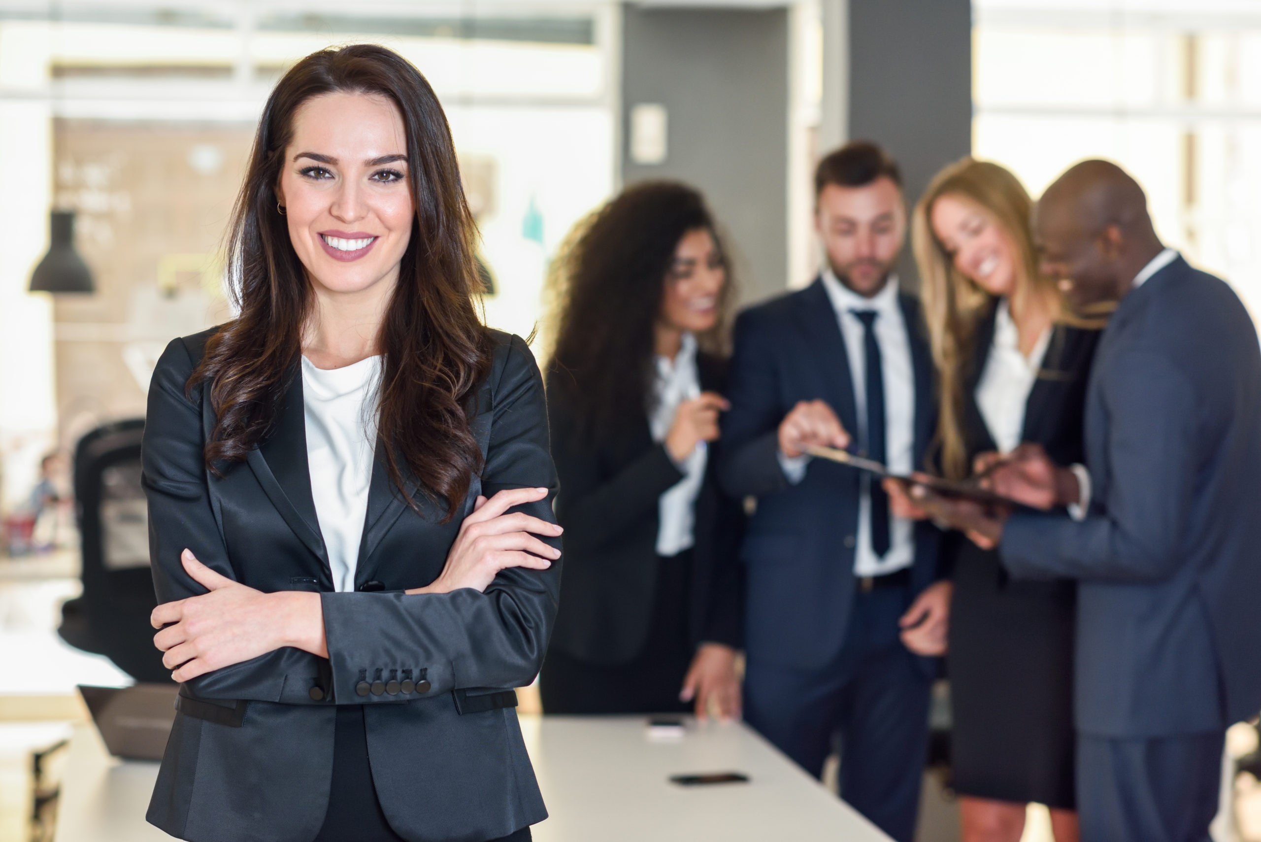 Protagonismo feminino: mulher empresária à frente de equipe de colaboradores de terno.